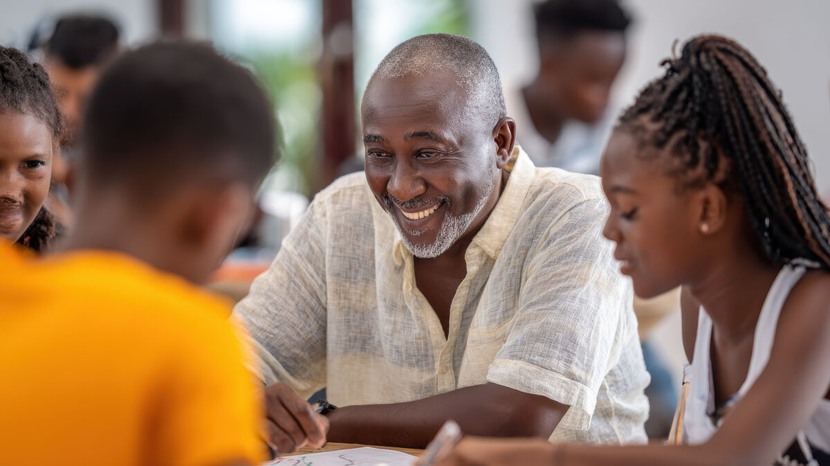 A program leader working with young people around a table
